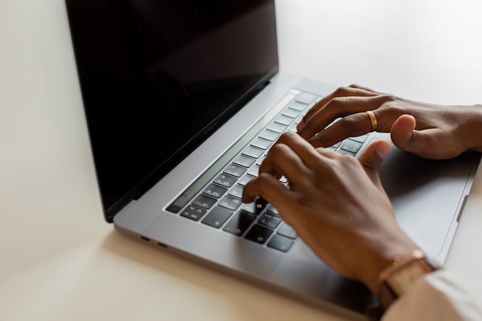close up of hands typing on laptop keyboard