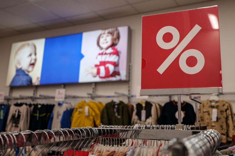 clothing racks with  signs in a department store