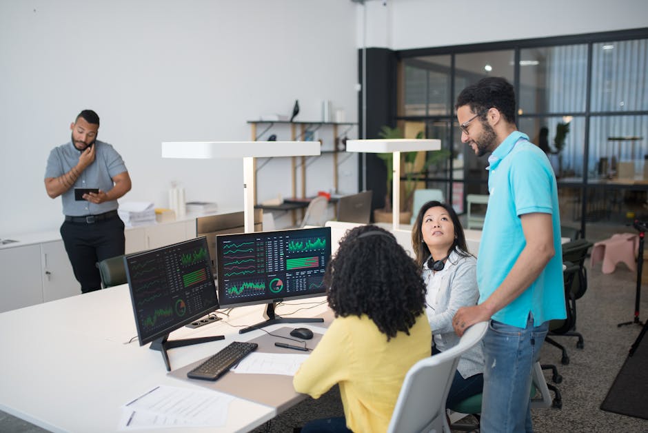 Diverse team collaborating in modern office with data dashboards