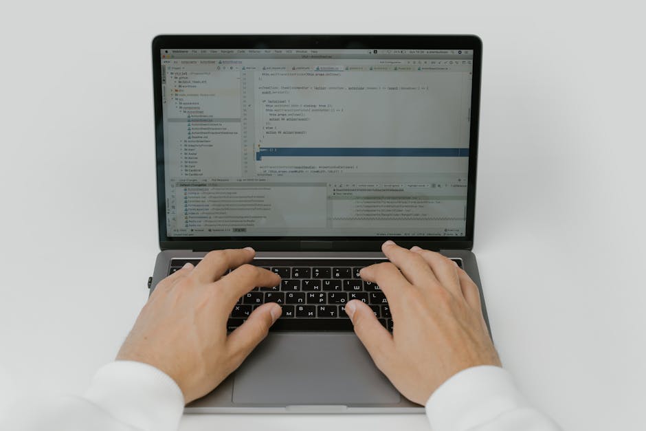 hands typing on laptop with French landscape in background