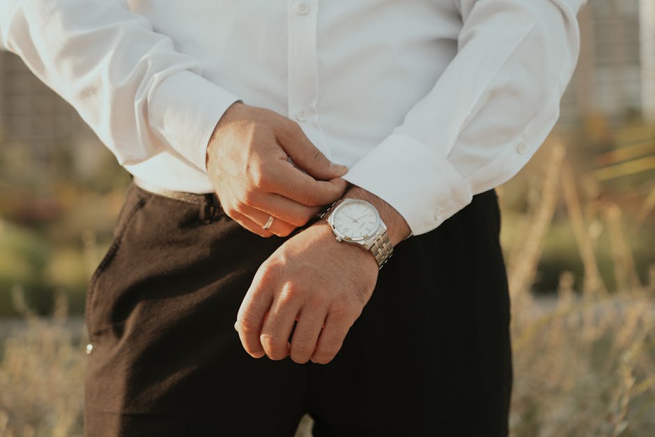 man adjusting watch in elegant outfit
