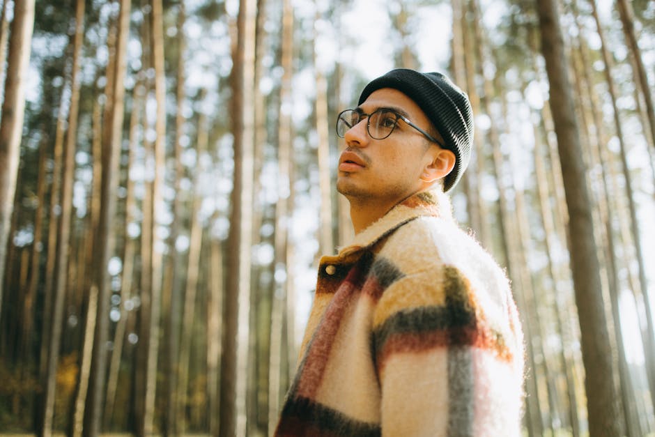 man in warm wool coat walking through autumn forest