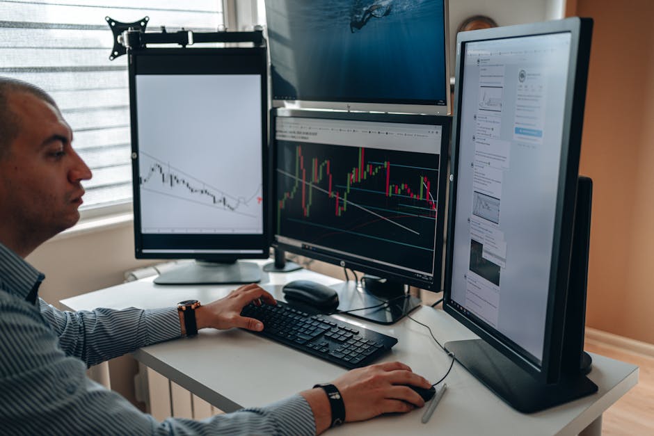 person looking at charts on multiple screens