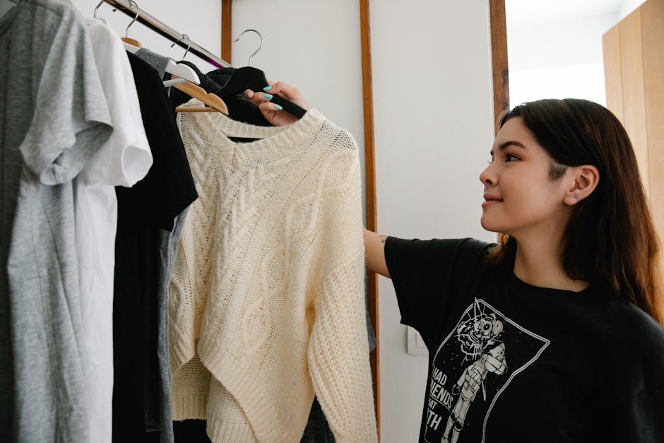 person organizing clothes in closet