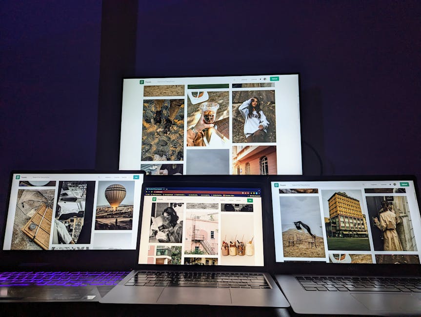 person writing on laptop with multiple screens