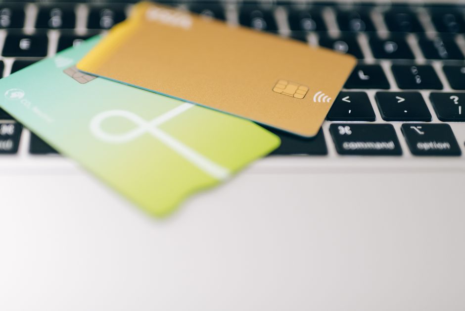 A pair of small shopping bags and a credit card resting on a laptop keyboard, symbolizing online purchasing and last-minute deals.