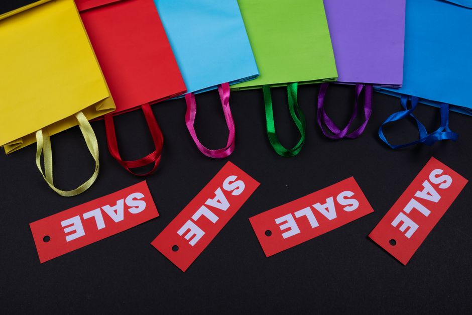 A collection of colorful shopping bags with various price tags and a blurry background.