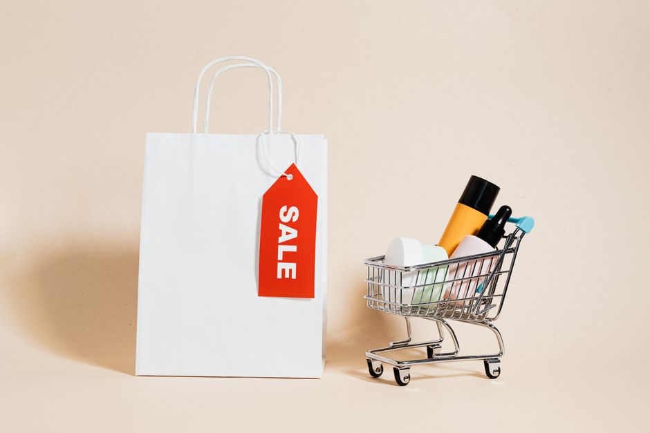 A shopping cart is filled with various beauty products, some adorned with small discount tags, representing the act of making smart online deals on cosmetics.