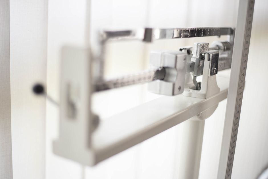 Three miniature shopping carts on a balance scale, illustrating the act of comparing different online deals and offers to find the best value.