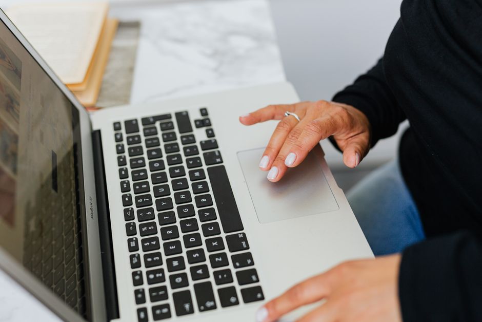 A person's hands researching beauty deals on a laptop, with multiple browser tabs open for different retailers.