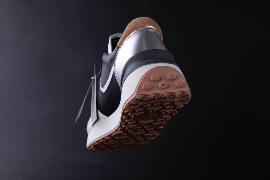 A detailed view of the inside of a comfortable walking shoe, highlighting the contoured arch support and thick, responsive cushioning designed for prolonged standing.