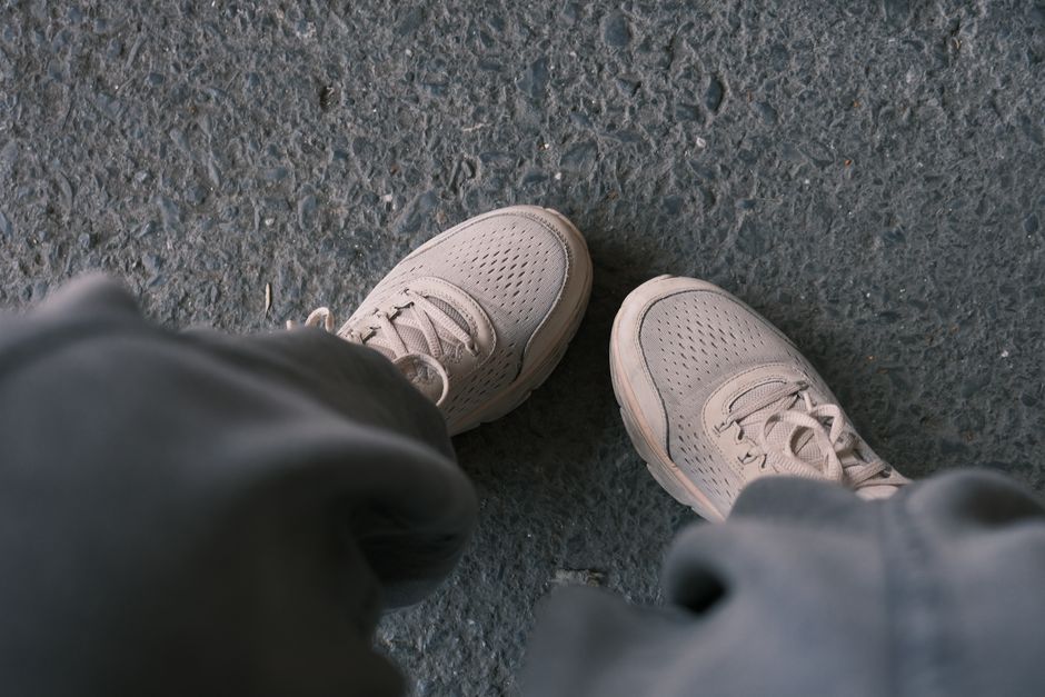 A person wearing comfortable walking shoes strolling on a European cobblestone street, emphasizing travel footwear suitability.