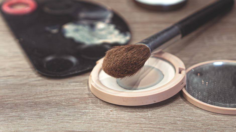 A curated, compact makeup kit featuring multi-tasking products like a tinted balm, small foundation, and mascara, ready for travel.