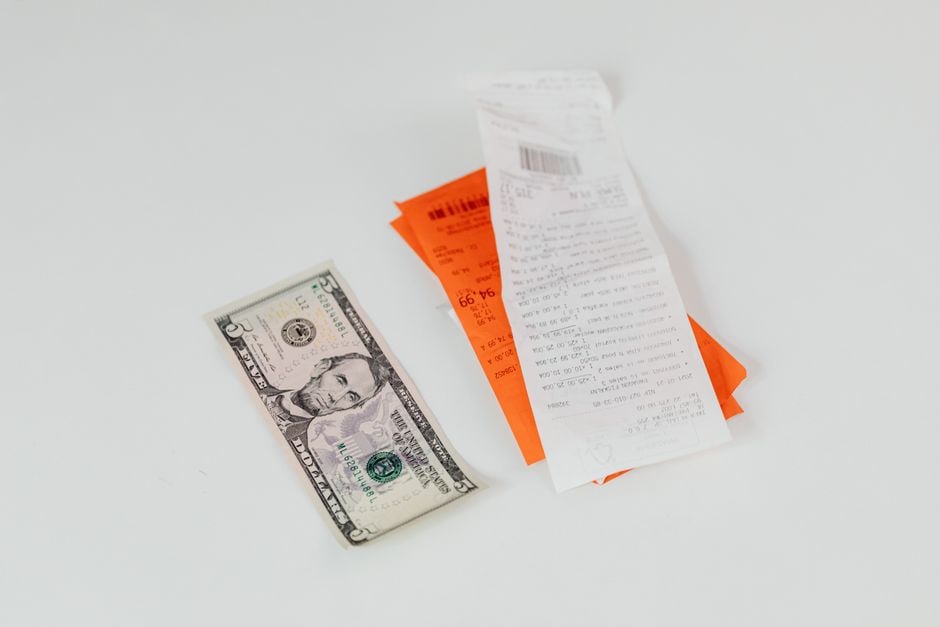 Two side-by-side shopping receipts, one clearly showing an unexpected fee or lower-than-expected discount, highlighting the need to compare final prices carefully.