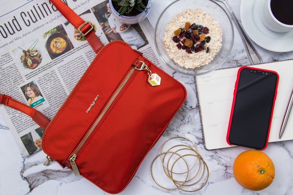 A close-up shot of a black anti-theft crossbody bag, showcasing features like locking zippers and a slash-resistant fabric texture.