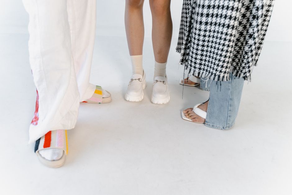 Multiple people's feet wearing different types of comfortable, supportive work shoes, showcasing variety and proper fit.