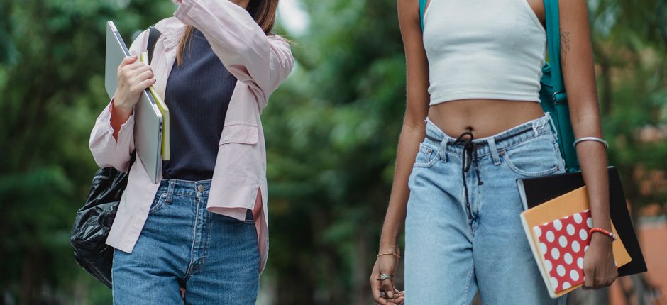 A neatly organized wardrobe closet displaying a versatile collection of women's jeans in various cuts and washes, alongside tops and accessories, illustrating capsule wardrobe principles.
