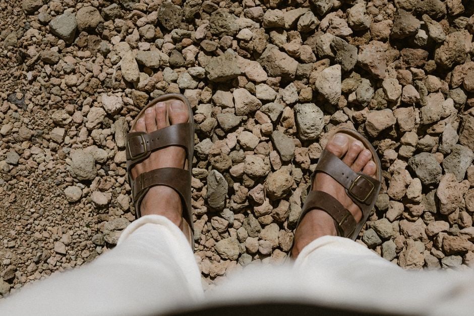 Pair of durable walking sandals with good traction on a classic European cobblestone street, ready for exploration.