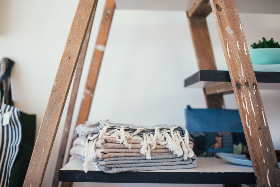 Close-up of neatly folded garments made from sustainable fabrics like organic cotton and linen, in neutral tones.