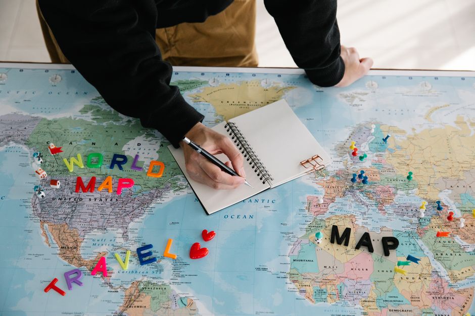 A world map with various travel icons, discount tags, and flight paths, representing the global scope of finding genuine travel discounts and offers.