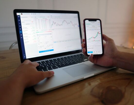 A laptop screen displaying a price tracking graph for an online product, with a smartphone showing deal alerts in the foreground.
