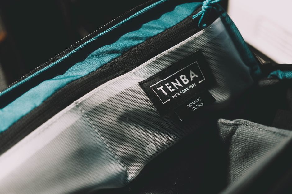 Close-up shot of a laptop bag's interior, showing a padded and suspended laptop sleeve, with a hand demonstrating its protective features.