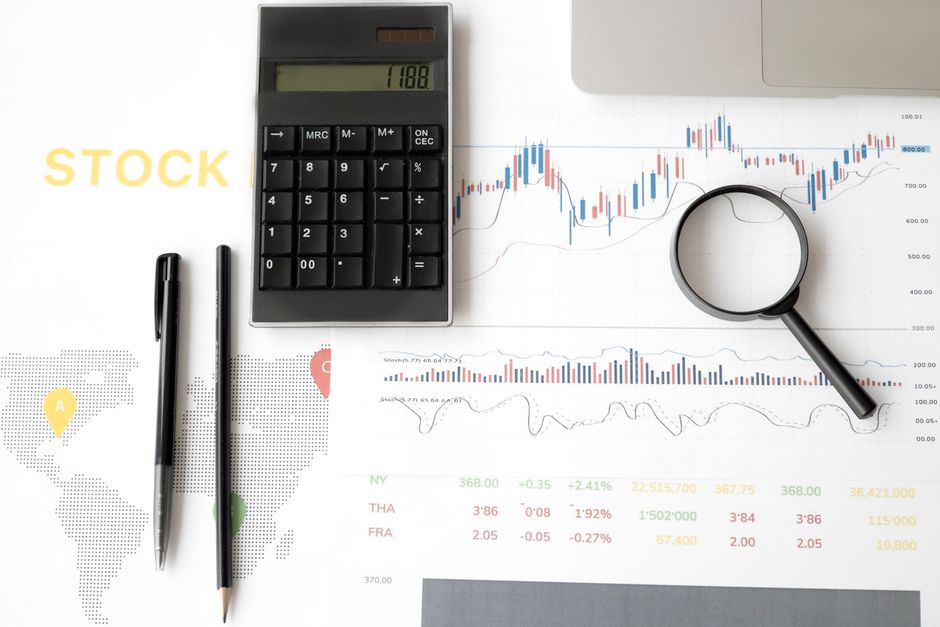 A close-up of a magnifying glass hovering over a fluctuating price chart on a computer screen, illustrating the concept of price tracking and historical data.