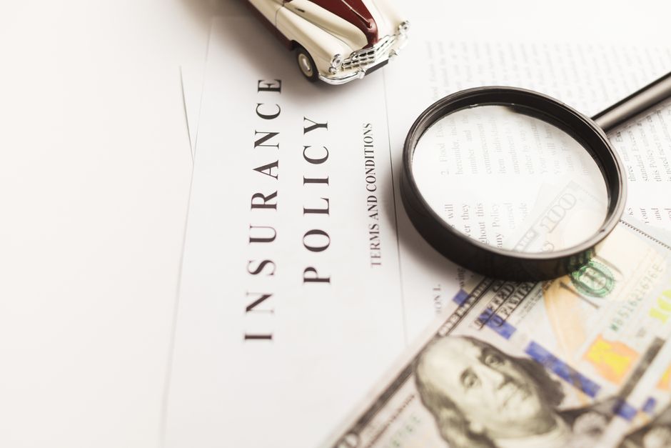 A close-up shot of a magnifying glass hovering over complex fine print in a travel booking contract, highlighting the importance of reading terms and conditions.