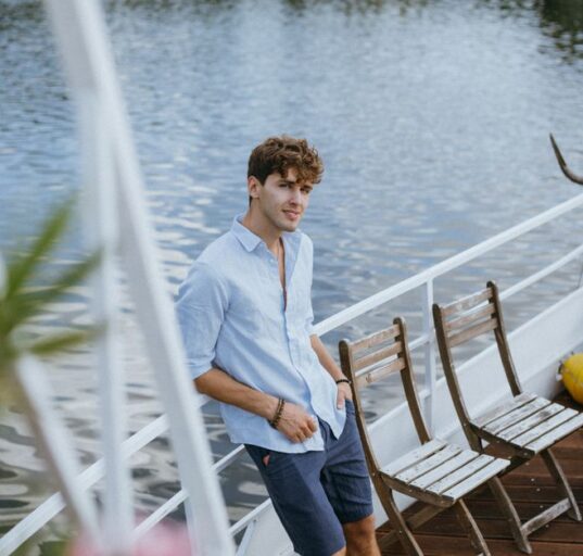 A man walking down a sunny street in lightweight linen shirt and tailored shorts, embodying comfortable summer style.
