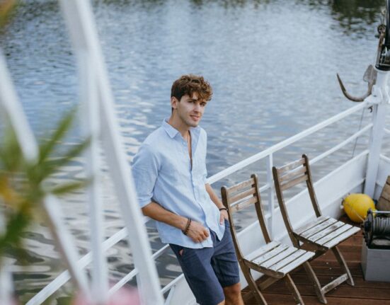 A man walking down a sunny street in lightweight linen shirt and tailored shorts, embodying comfortable summer style.