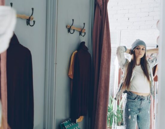 Man using augmented reality to see how jeans fit on a screen, demonstrating online shopping for men's fashion.