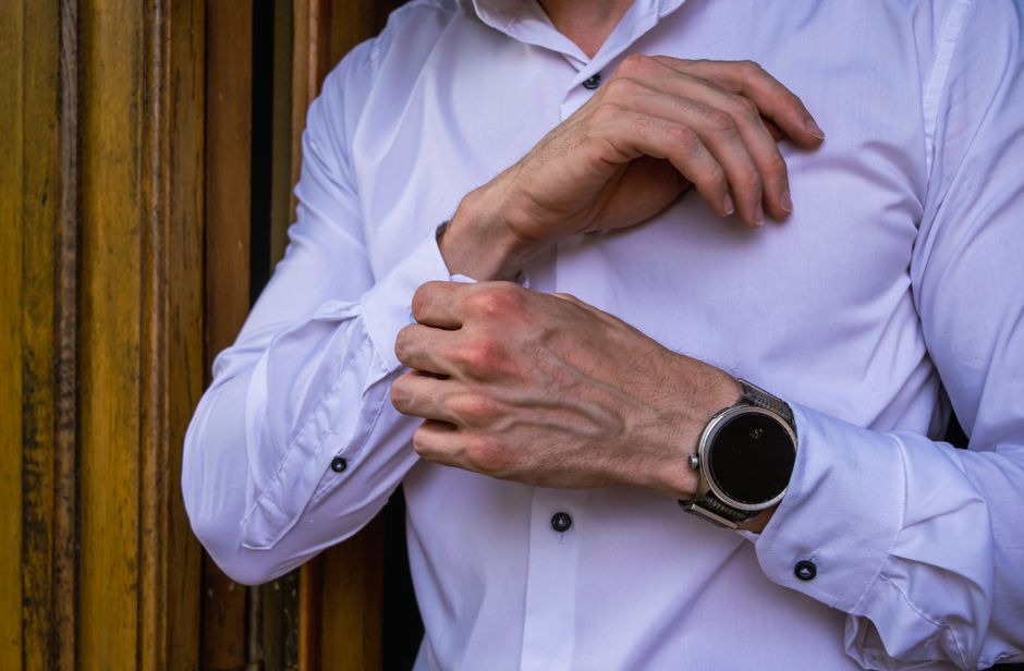 A confident man walking in a city street, wearing a perfectly fitted navy blazer, light blue Oxford shirt, tailored chinos, and clean white sneakers, embodying smart casual style.