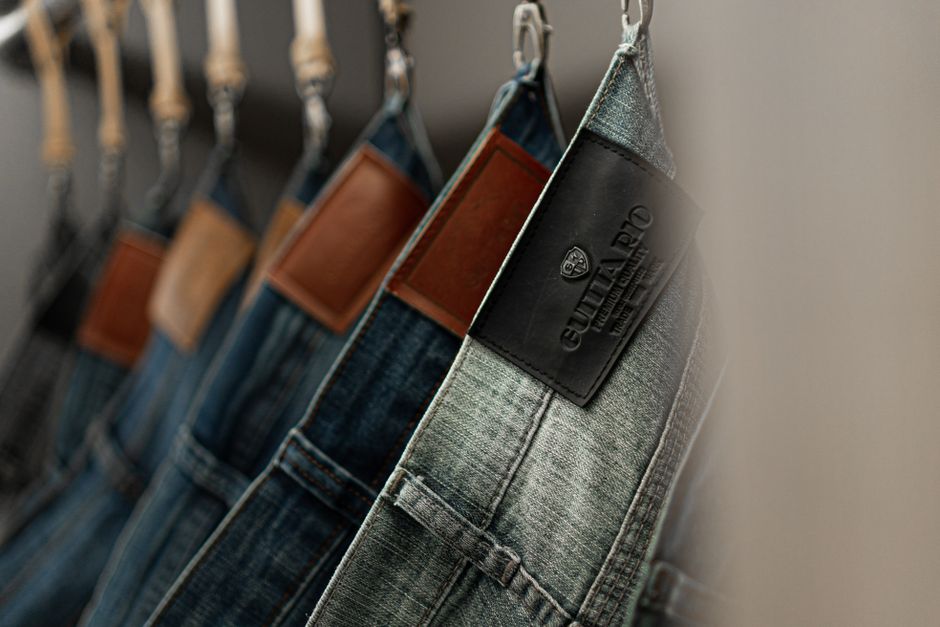 A neatly organized men's wardrobe with a selection of different jean washes and styles, alongside shirts and jackets.