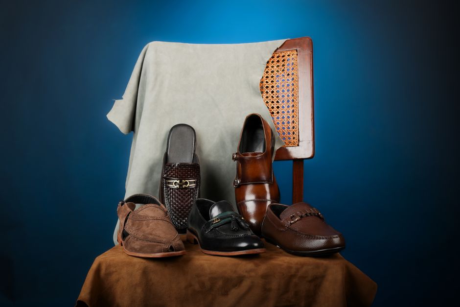 A carefully arranged selection of polished leather men's office shoes, including black Oxfords, dark brown Derbies, and burgundy loafers, displayed on a wooden surface.