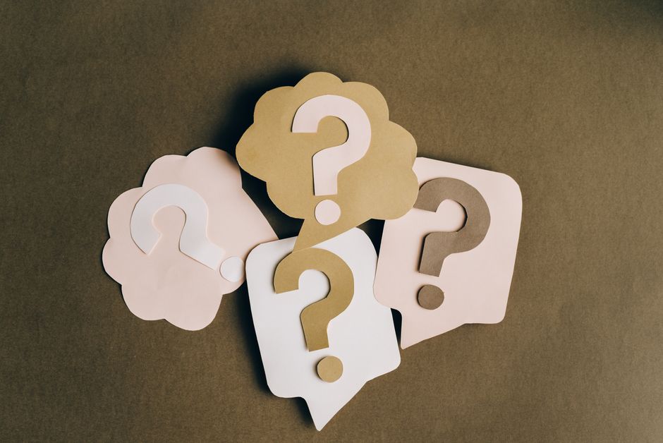 A graphic representation of an online shopping cart filled with items, surrounded by small text and question marks, illustrating the complexities of understanding offer exclusions and conditions.