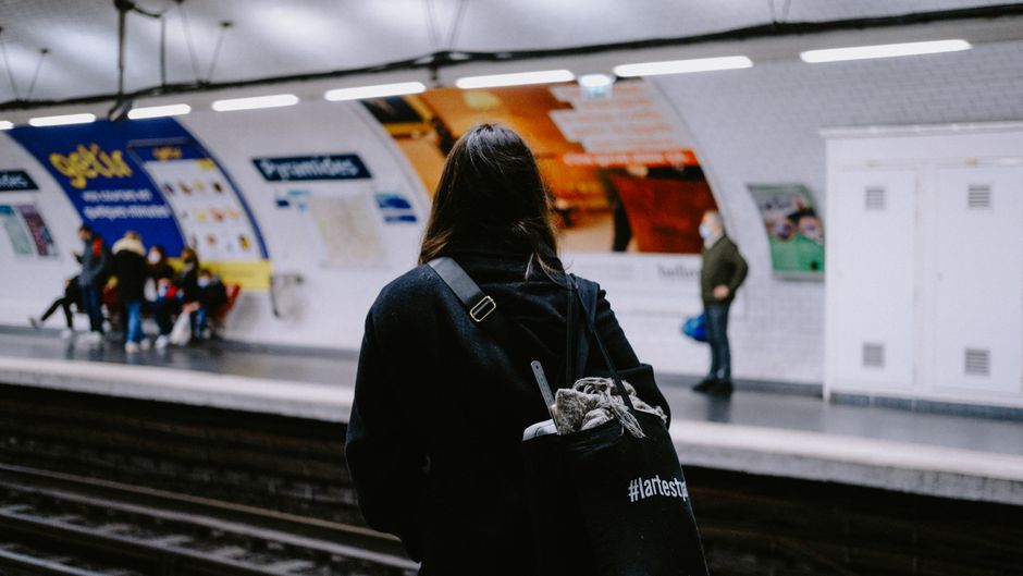 A professional commuter on a train, wearing an ergonomic anti-theft backpack, comfortably using a tablet.