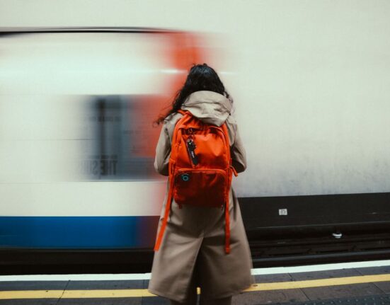 A person walking through a modern city street with a stylish yet protective laptop backpack.
