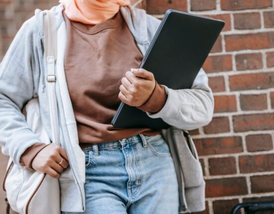 A professional walking with a stylish laptop backpack through a modern European city street, demonstrating practical urban commuting.