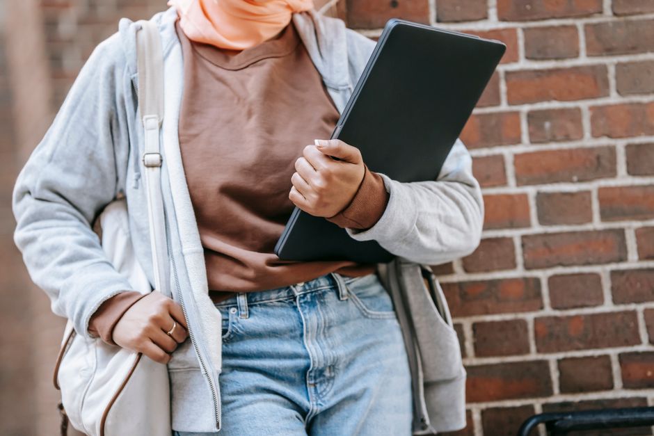 A professional walking with a stylish laptop backpack through a modern European city street, demonstrating practical urban commuting.