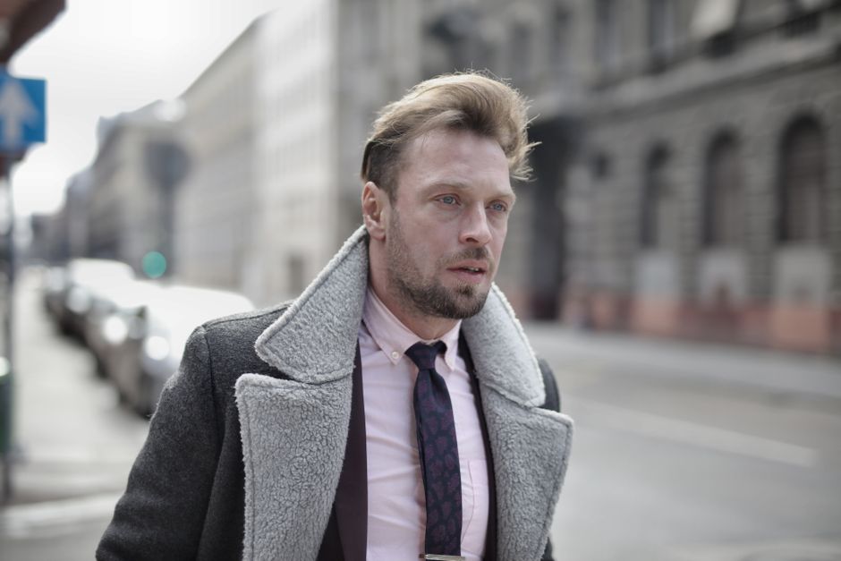 A man dressed in smart casual winter layers, featuring a textured mid-layer and a well-fitting overcoat, perfect for urban environments.
