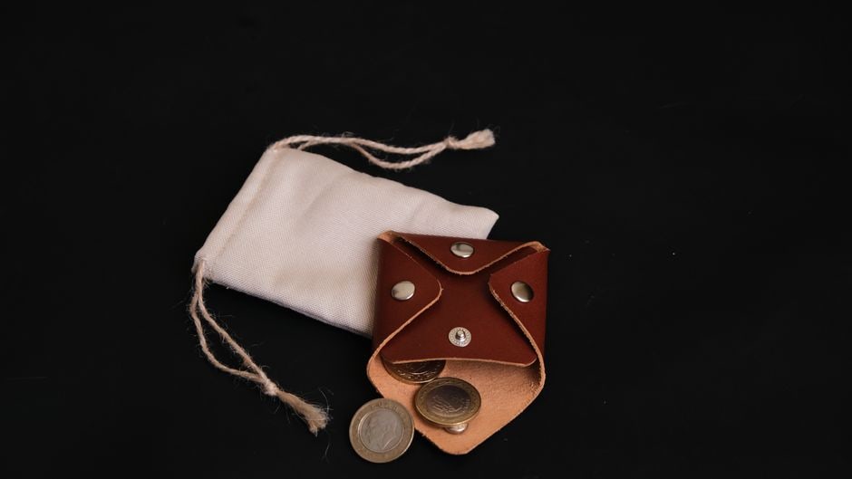 A flat lay arrangement of different sized and colored small travel pouches and organizers, demonstrating how to keep essentials tidy.