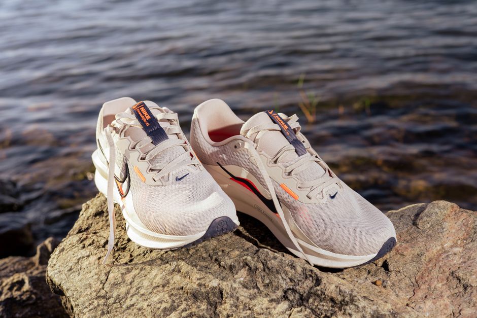 A side-by-side comparison of a running shoe and a walking shoe on a clean white background, highlighting their different sole designs.
