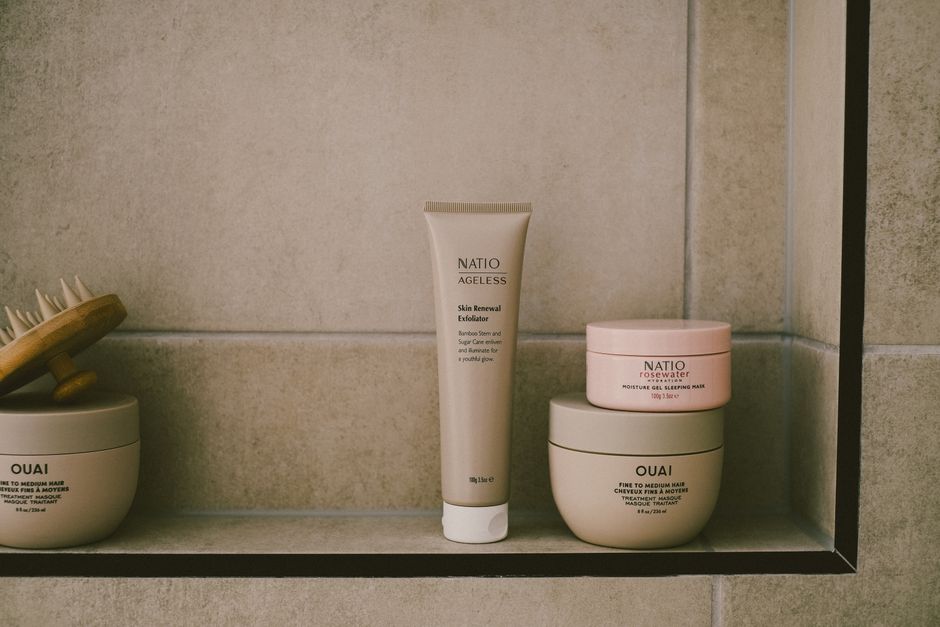 A selection of affordable beauty products—cleanser, moisturizer, and SPF—neatly arranged on a simple bathroom shelf, representing a practical beauty and skincare guide.