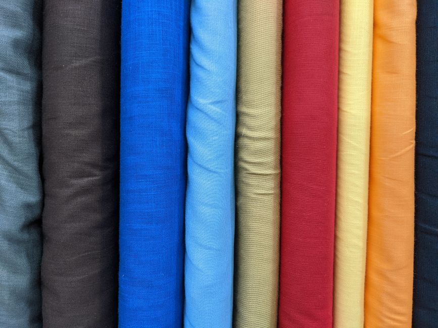 Close-up of various sustainable fabric swatches, including linen, cotton, and Tencel, ideal for summer.