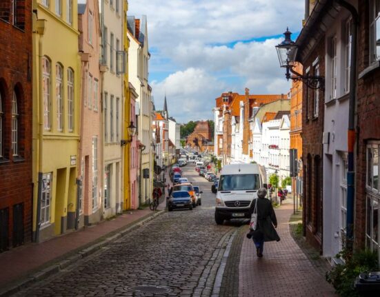 A person in comfortable walking shoes navigating ancient, uneven cobblestones in a European city.