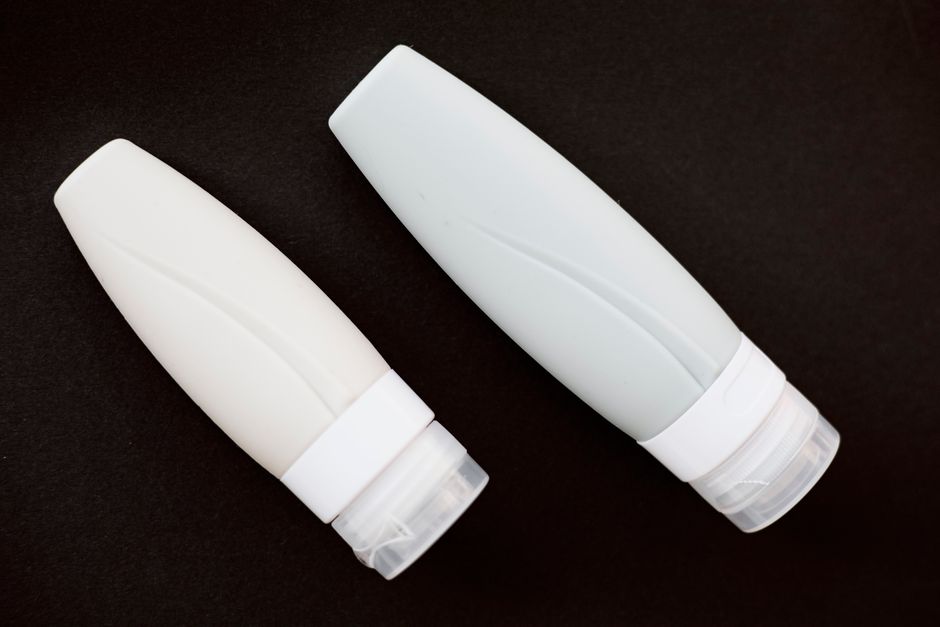 A clear TSA-approved bag filled with miniature skincare and beauty products for travel.