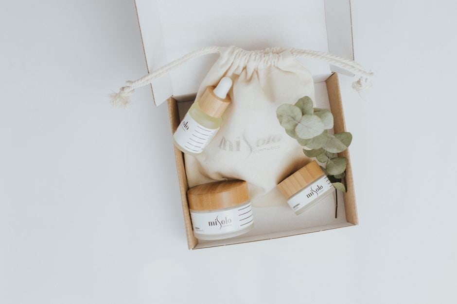 A neatly organized clear toiletry bag filled with travel-sized bottles of skincare essentials like hyaluronic acid serum, SPF, and a cream cleanser, ready for a trip.
