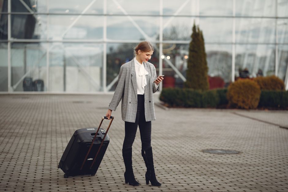 A traveler at an airport security checkpoint easily accessing items from their crossbody bag, highlighting its convenience.