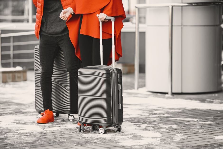 A person confidently navigating a busy airport concourse, pulling a sleek spinner carry-on bag, symbolizing efficient work and travel.