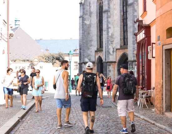 A person walking through a bustling European city street, carrying a discreet anti-theft backpack, blending in with the crowd.